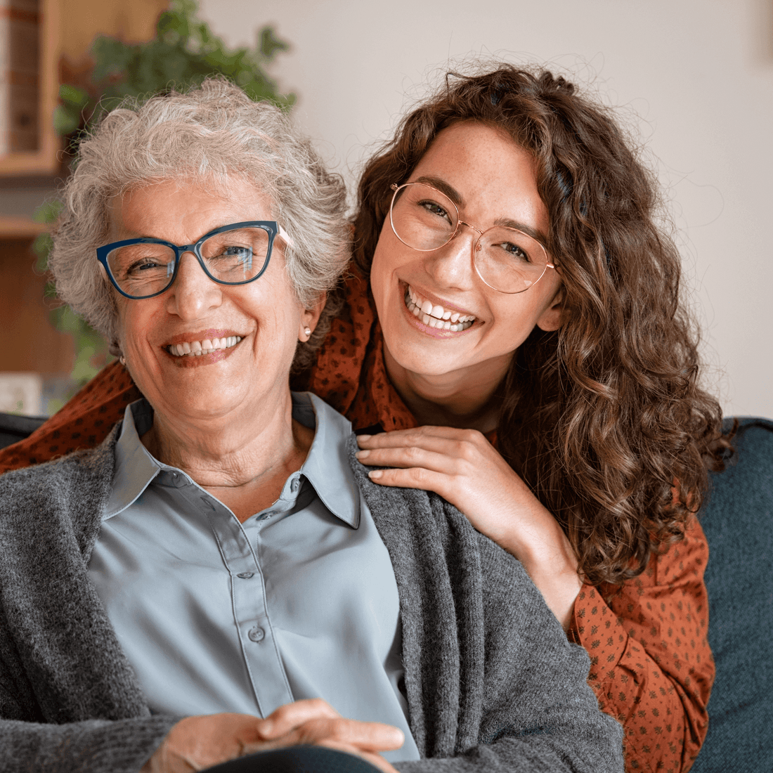 A smiling elderly woman and young woman share a joyful moment together, embodying love and connection.